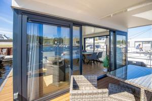 a glass house with a view of the water at Hausboot Träumerei - LP3 in Peenemünde