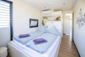 a bed with blue and white striped pillows on it at Hausboot Träumerei - LP3 in Peenemünde +13 photos