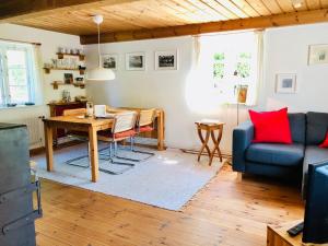 a living room with a table and a blue couch at Tante Kamps Hus - Uriges Häuschen mit Garten und Geschichte in Bönstrup +14 photos