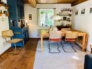 a dining room with a wooden table and chairs at Tante Kamps Hus - Uriges Häuschen mit Garten und Geschichte in Bönstrup