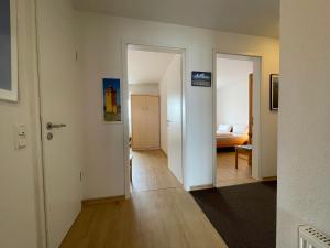 a hallway with two doors and a bed in a room at Apartment 22 in Wilhelmshaven +7 photos