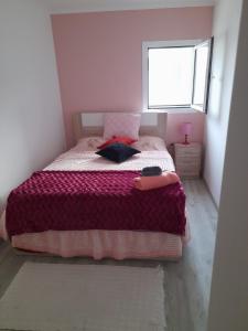 a bedroom with a bed with a purple blanket and a window at Paraíso da Foz do Sabor in Torre de Moncorvo