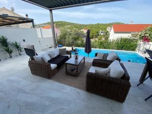 a patio with couches and a table and a pool at Villa Maris in Ražanj
