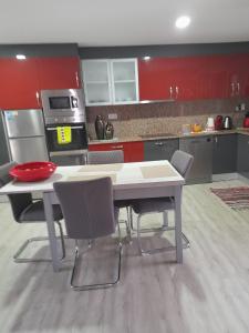 a kitchen with a table and chairs and red cabinets at Paraíso da Foz do Sabor in Torre de Moncorvo +15 photos