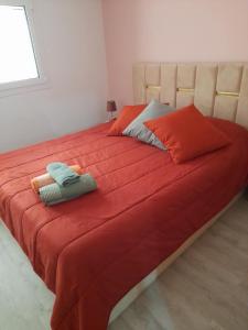 un grande letto con lenzuola rosse e cuscini sopra di Paraíso da Foz do Sabor a Torre de Moncorvo