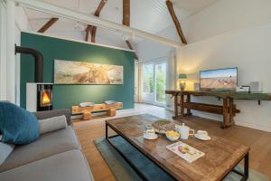 a living room with a couch and a table at Klüterkammer, Ferienhaus auf Gutshof mit Kamin in Langballig