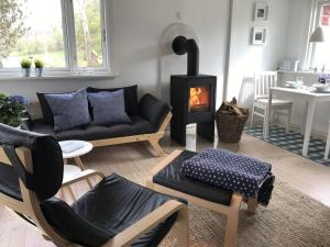 ein Wohnzimmer mit Sofa und Kamin in der Unterkunft Blaue Pause - Hygge-Häuschen mit Garten und Kamin in Langballig