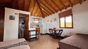 Una habitación con una cama y una cocina con una mesa. en Guille Bungalows, en Canoas de Punta Sal