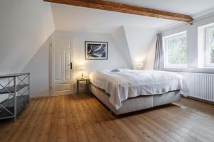 Un dormitorio blanco con una cama y dos ventanas. en Bauernhaus am Mühlendamm, en Steinbergkirche