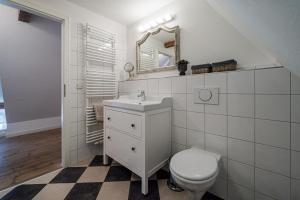 Un baño blanco con inodoro y espejo. en Bauernhaus am Mühlendamm, en Steinbergkirche 20 fotos más