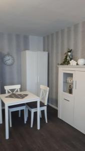 a kitchen with a white table and chairs and a cabinet at Fewo 25 in Goslar
