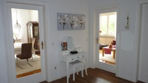 a white room with a vanity and a mirror at Apartment Kunsthaus Panorama 1 OG mit Balkon in Nordhausen +16 photos