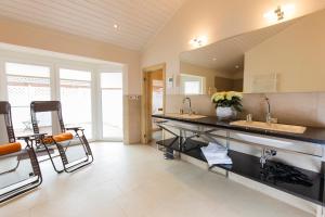 a large kitchen with two sinks and two mirrors at Wellnesshaus "Wind" in Fehmarn