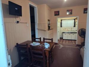 Depto 2 Chelson centro في فيلا جيزيل: مطبخ وغرفة طعام مع طاولة وتلفزيون