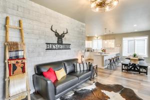 a living room with a leather couch in front of a wall at Home Base for Final Rally Weekend w/ Heated Garage in Spearfish