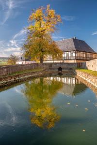 a building with a bridge over a river with a tree at Ferienwohnung "Zum Schloßkeller" in Wolkenstein
