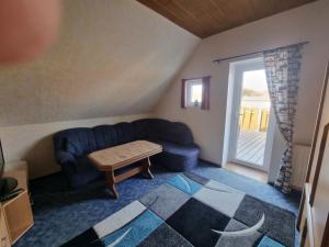 a living room with a blue couch and a table at Fewo Janssen in Borkum