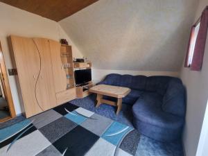 a living room with a blue couch and a table at Fewo Janssen in Borkum
