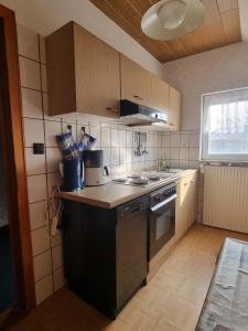a kitchen with a sink and a stove top oven at Fewo Janssen in Borkum +2 photos