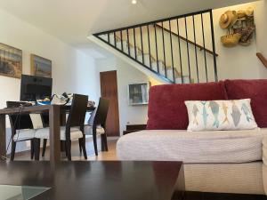 een woonkamer met een bank en een eettafel bij Tu casa en Doñana in Matalascañas