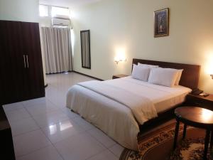 a bedroom with a large bed and a table at Royal Gibson Hotel in Kitwe +22 photos