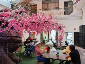 a group of people sitting at tables with pink flowers at UMAI Palace in Arequipa