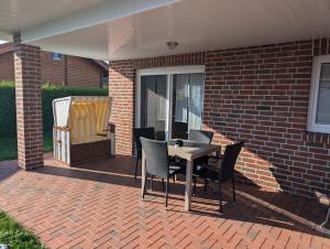 a patio with a table and chairs on a brick wall at Haus Colonia in Walchum