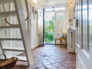 pasillo con escalera y puerta abierta en altes Kapitänshäuschen, en Prerow