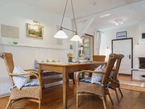 Un comedor con mesa y sillas de madera. en altes Kapitänshäuschen, en Prerow