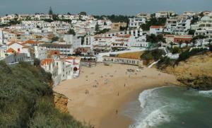 a group of people on a beach near the ocean at Casa Caracol in Praia do Carvoeiro