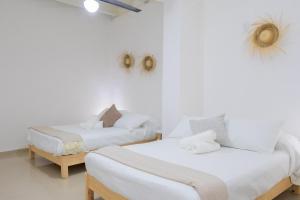 twee bedden in een kamer met witte muren bij NEW! Aldea Bamboo 3 Terrace & Centro in Cuernavaca