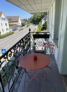 a table on a balcony with a red cup on it at Grosse Neue Wohnung in Bern mit Whirlpool in Bern