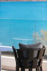 a chair sitting in front of a glass table at Naiades Boutique Hotel - Adults Only in Elounda