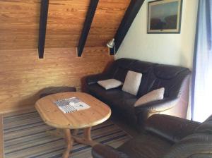 a living room with a couch and a table at Fewo Hoogen in Strandnähe in Friedrichskoog-Spitz