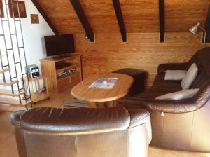 a living room with a couch and a table at Fewo Hoogen in Strandnähe in Friedrichskoog-Spitz