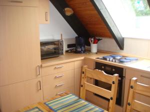 a kitchen with a microwave and a table and a chair at Fewo Hoogen in Strandnähe in Friedrichskoog-Spitz +12 photos