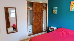 1 dormitorio con 1 cama roja y 2 espejos en El Buen Vivir, en Mar del Plata