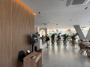 a lobby with people sitting at tables and a tv at Suite con Lujoso Jacuzzi, Piso 14 y vista al mar in Santa Marta