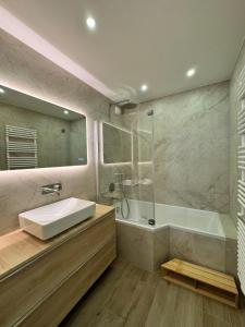 Un baño con lavabo, ducha y bañera. en appartement spacieux, en Clichy