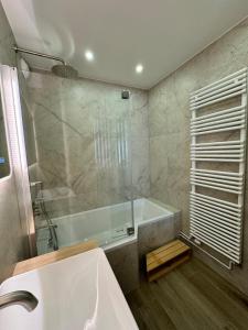 a bathroom with a bath tub and a sink at appartement spacieux in Clichy +18 photos