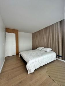 1 dormitorio con 1 cama grande y pared de madera en appartement spacieux, en Clichy 18 fotos más