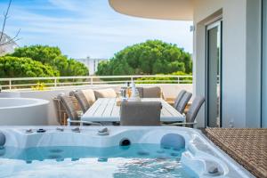 a hot tub on a balcony with a table and chairs at Le SALTA in La Grande-Motte