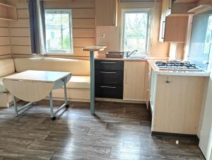 a kitchen with a stove and a table in it at Mobil-Home Provence in Cheval-Blanc