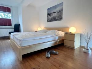 a bedroom with a bed with two lamps and a pair of shoes at Ferienwohnung Ost in Fehmarn
