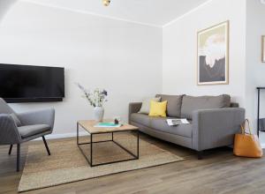 ein Wohnzimmer mit Couch und Fernseher in der Unterkunft Villa Fortuna - Suite mit Terrasse in Ostseebad Sellin