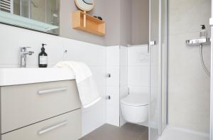 ein weißes Badezimmer mit Dusche und Toilette in der Unterkunft Villa Fortuna - Suite mit Terrasse in Ostseebad Sellin