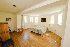 NeuenkirchenFerienwohnung 2 mit schönem Seeblick的卧室配有一张床、木地板和窗户。