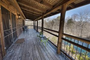 un porche de una cabaña con sillas y mesas en Bushwood Cabin, en Logan