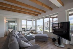 a living room with a large couch and a flat screen tv at ancora Marina Haus 2 Penthouse in Neustadt in Holstein