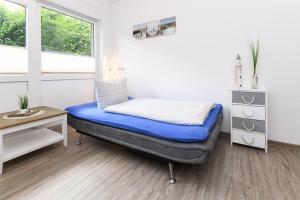 a room with a bed and a desk and a window at Ferienwohnungen Haus Boje "Scholle" in Neuharlingersiel